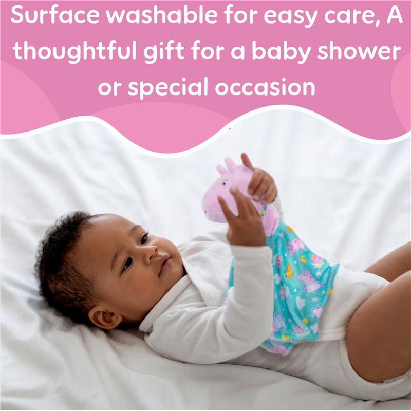Child playing with a Peppa Pig puppet blankey, smiling while holding it, on a soft white surface.