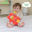 Child interacting with a red Elmo plush activity toy featuring teething rings, promoting sensory play and comfort.