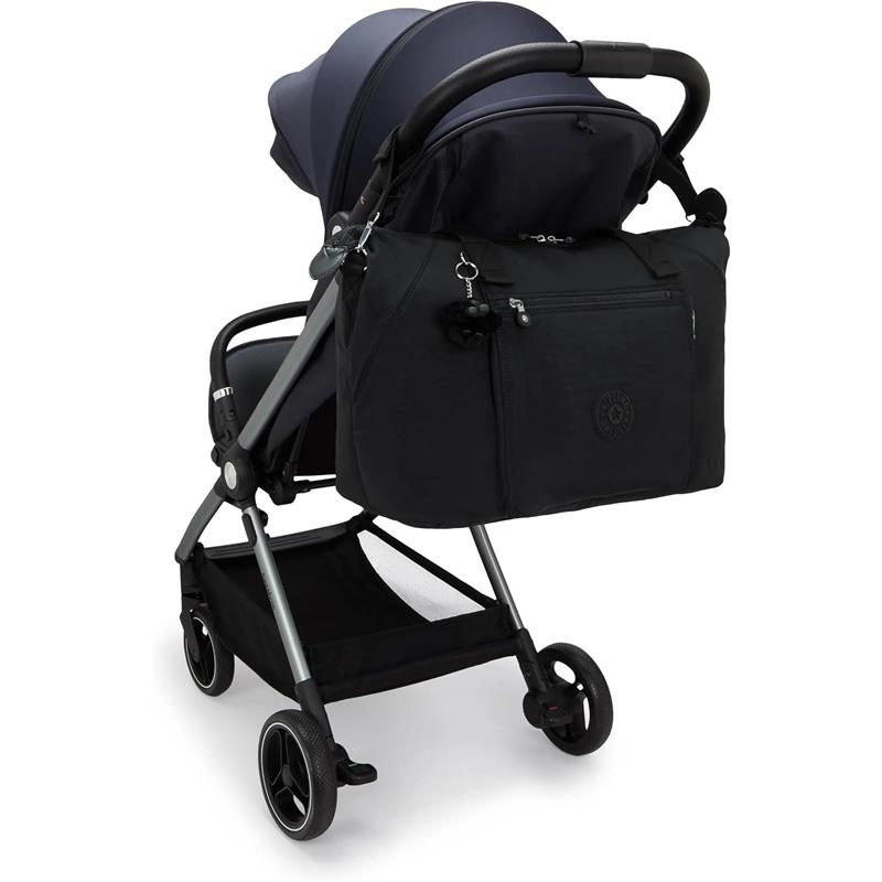 Kipling Art Baby Diaper Bag in Black Noir attached to a stroller, featuring a front zip pocket and charm.