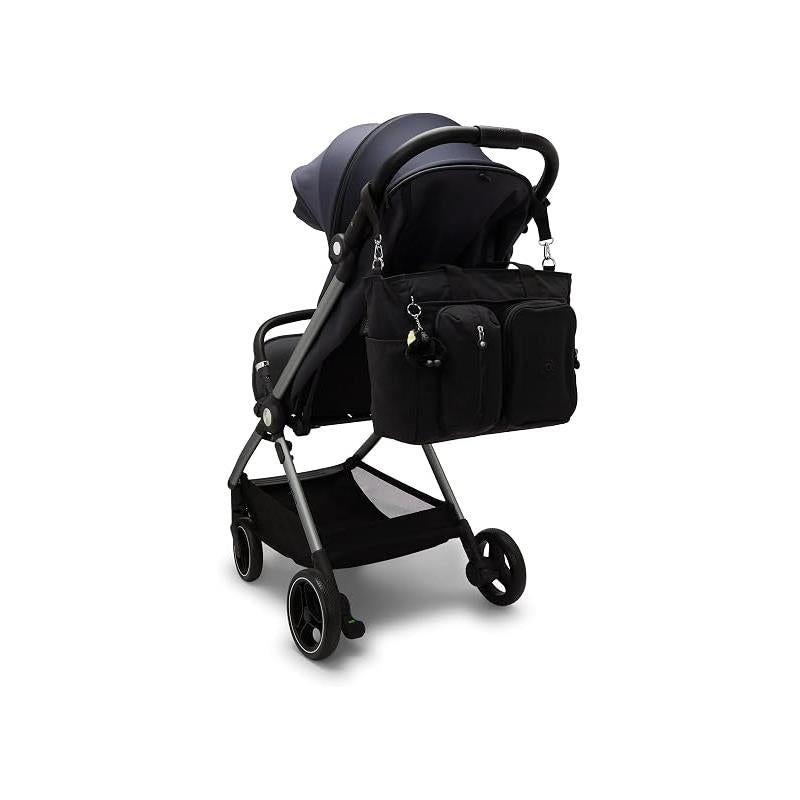 Convertible diaper backpack in Tiny Black Noir attached to a modern stroller, featuring multiple zippered pockets and a keychain accessory.