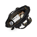 Convertible diaper backpack in Tiny Black Noir with items inside, including wipes, a bottle, and a toy, featuring a banana-patterned interior.
