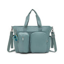 Convertible diaper backpack in Tiny Green Air color with front zip pockets and detachable charm.