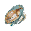 Convertible diaper backpack in Tiny Green Air with a banana-patterned interior, containing bottles, diapers, and keys.