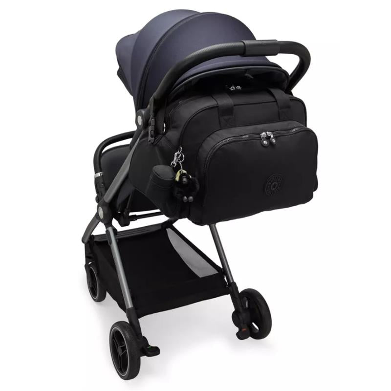 Kipling Camama Diaper Bag in Tiny Black Noir attached to a stroller, featuring a keychain and bottle holder.