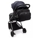 Kipling Camama Diaper Bag in Tiny Black Noir attached to a stroller, featuring a keychain and bottle holder.