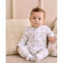 Infant wearing Kissy Kissy Fun On the Farm Zip Footie, featuring playful animal and farm-themed prints, seated on a couch.