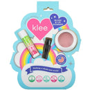 Blush and lip shimmer set featuring Klee Naturals products: a pink blush and two lip shimmers on a colorful cloud background.
