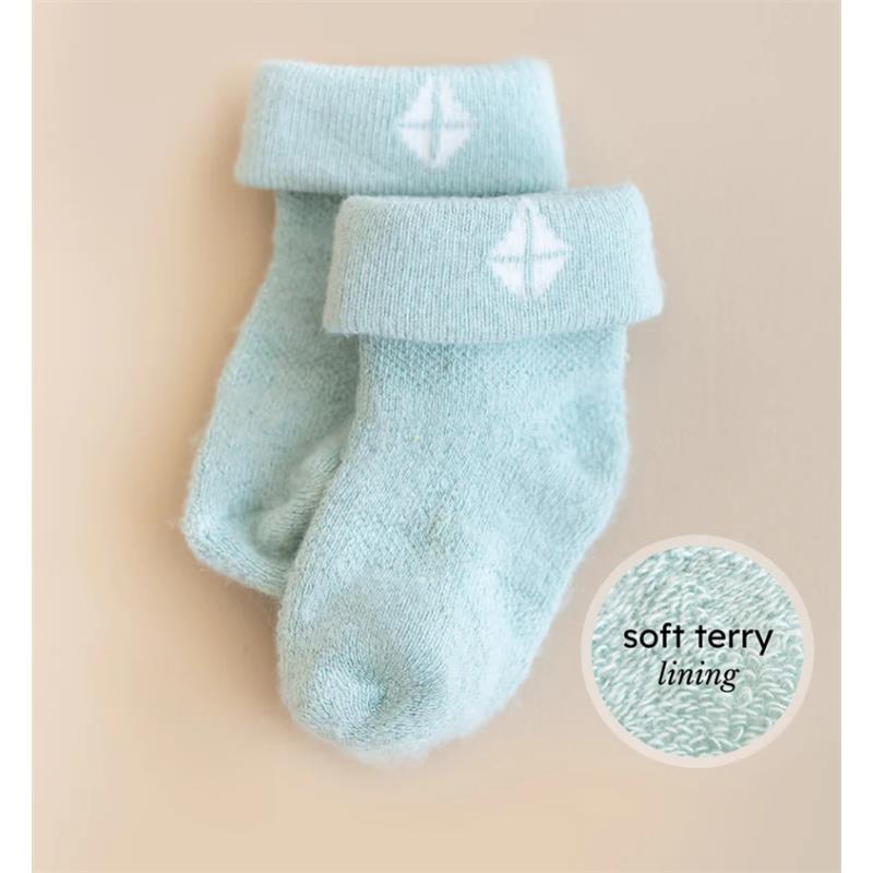 Soft blue baby socks with a cuff and white logo, highlighting the soft terry lining.