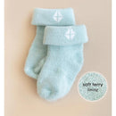 Soft blue baby socks with a cuff and white logo, highlighting the soft terry lining.