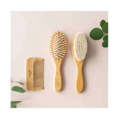 Bamboo brush and comb set by Kyte Baby, featuring a wide-tooth comb and two brushes with soft bristles.