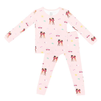 Long sleeve pink pajamas for baby girls featuring Barbie™ beach-themed prints with sun, flowers, and vintage cars.