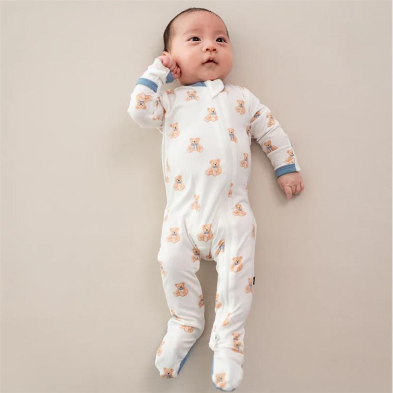 Baby wearing a Kyte Baby zippered footie with teddy bear prints, lying on a soft background.