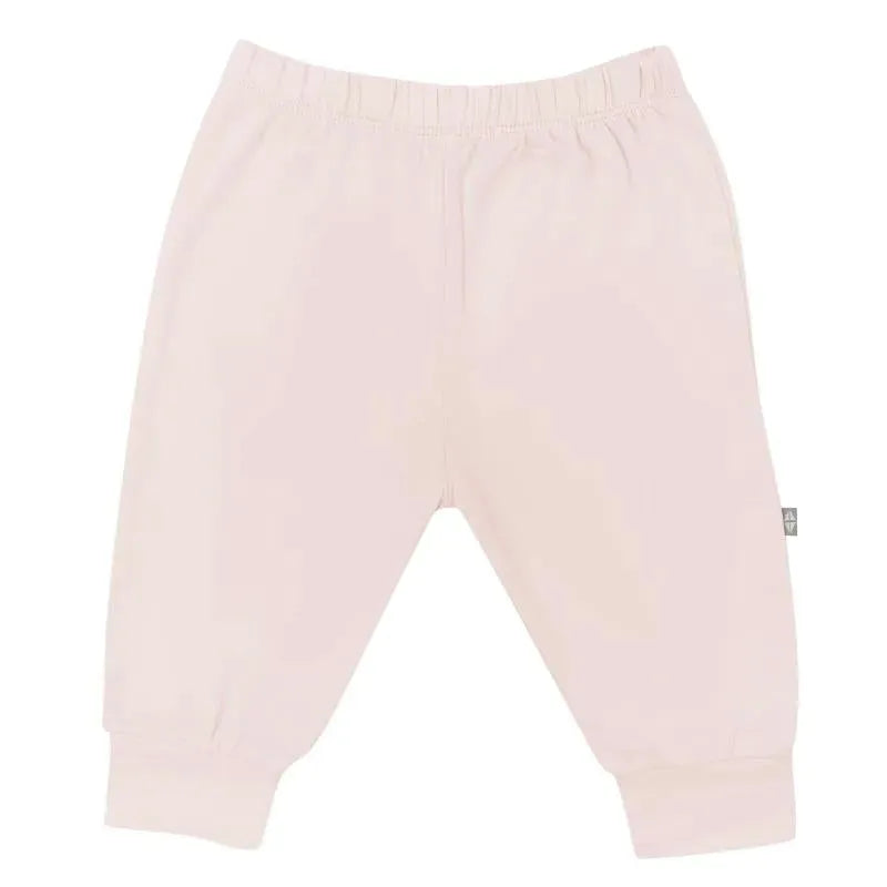 Blush-colored baby pants with an elastic waistband and gathered ankle cuffs, designed for comfort and style.