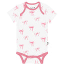Kyte Baby bodysuit featuring a white background adorned with pink bow patterns and pink trim around the neckline and legs.