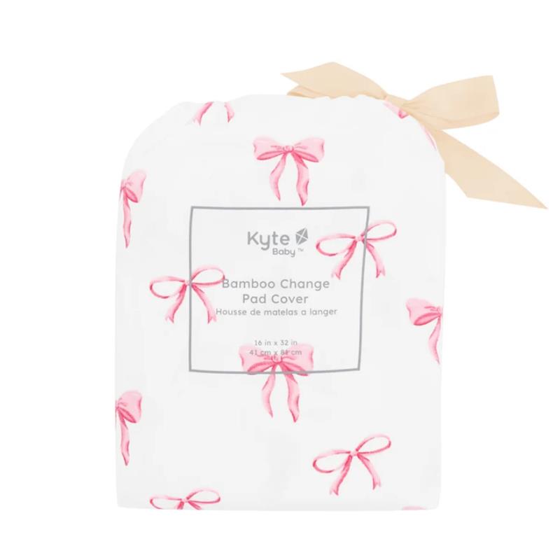 Kyte Baby bamboo change pad cover in white with pink bow print, featuring product details on the label.