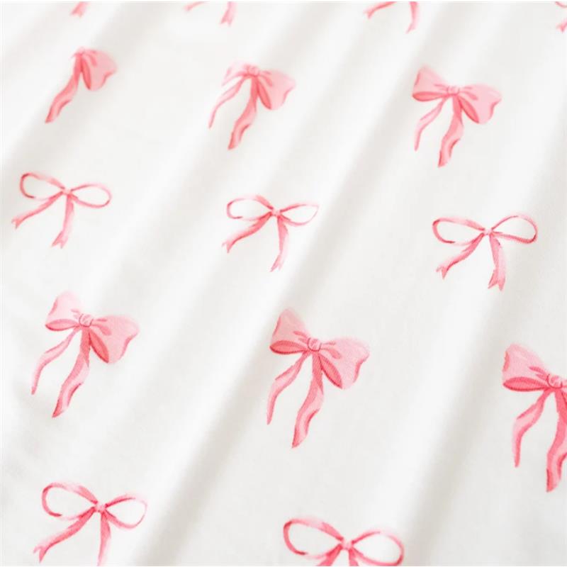 Kyte Baby Change Pad Cover in Bow features a soft white fabric adorned with repeating pink bow patterns.