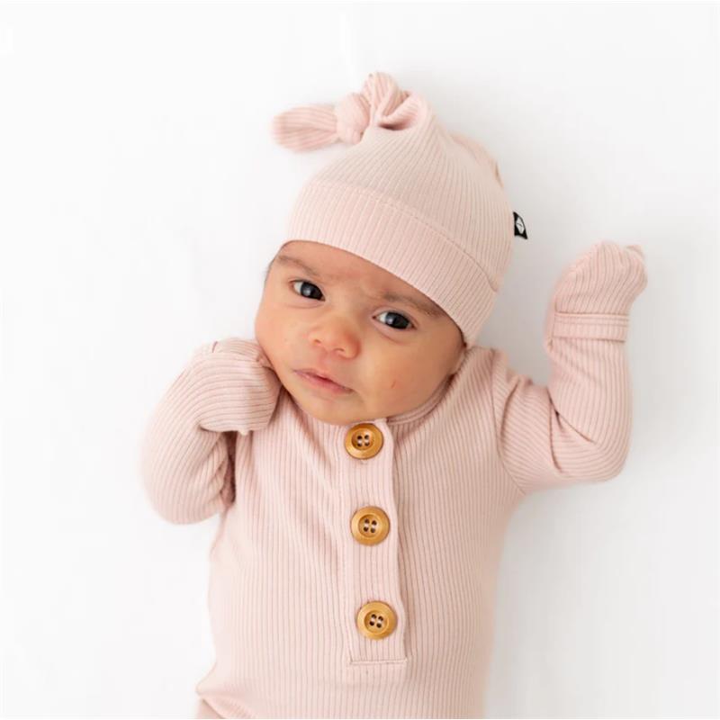 Ribbed blush knotted gown and hat set worn by a baby, featuring buttons and soft fabric.