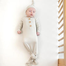 Ribbed, oat-colored knotted gown with hat set for infants, featuring wooden buttons and a soft, cozy design.