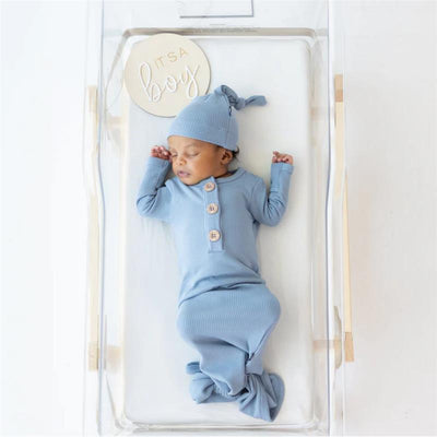 Ribbed slate knotted gown and hat set for a baby boy, featuring three buttons, displayed in a clear crib.