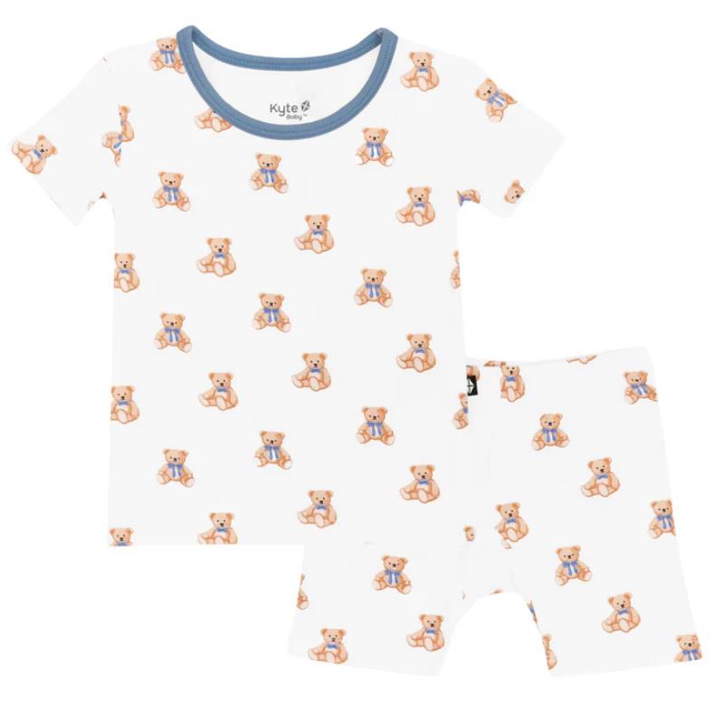 Short sleeve pajamas for kids featuring a teddy bear print, made from soft fabric with a blue trim.