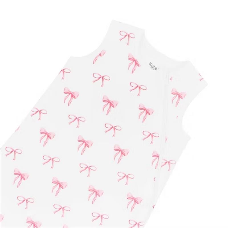 Kyte Baby Sleep Bag in Bow 1.0 Tog, featuring a white fabric with pink bow patterns and a side zipper for easy dressing.