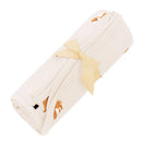 Kyte Baby swaddle blanket in fluffy dog design, rolled and tied with a yellow ribbon, featuring playful dog illustrations.