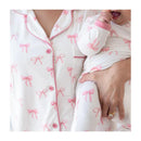 Women’s short sleeve pajama set featuring a bow print, with a parent holding a baby dressed in matching pajamas.