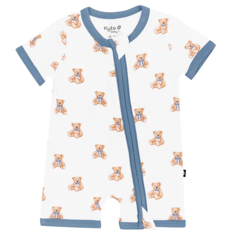 Zippered shortall romper featuring a teddy bear print on a white background with blue trim.