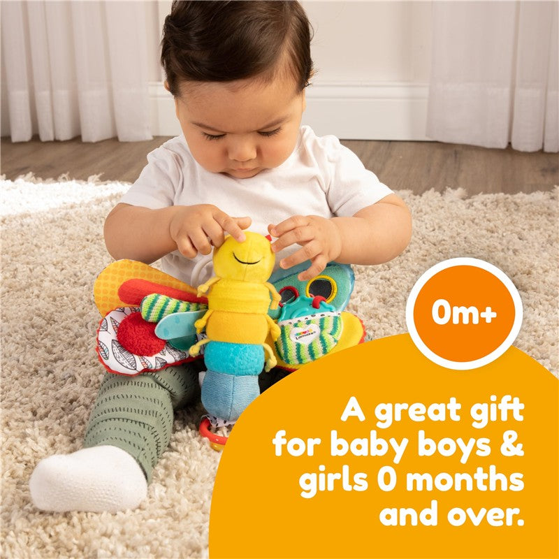 Infant playing with Lamaze Freddie the Firefly, a colorful plush toy designed for sensory exploration.