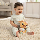 Smiling toddler sitting on a soft rug, holding the Lamaze Lovey The Pug Clip & Go toy with colorful patterned accents.