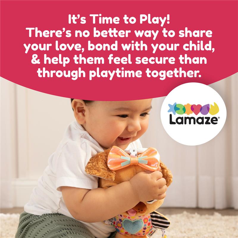Infant smiling while hugging a stuffed dog toy with a bow, promoting the Lamaze Lovey The Pug Clip & Go.