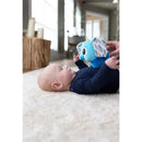 Baby lying on a soft rug, reaching for a blue elephant sensory toy with patterned ears, encouraging interaction and play.