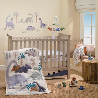Blue and gray dinosaur crib bedding set featuring a comforter and fitted sheet, with dinosaur wall decals and a mobile.