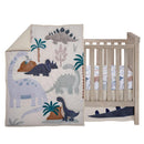 Dinosaur-themed nursery crib bedding set featuring a blue and gray quilt with playful dino appliqués and a matching crib skirt.