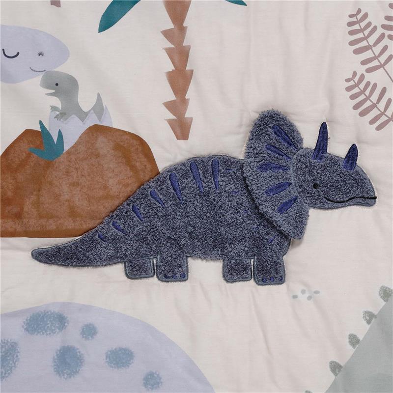 Blue and gray dinosaur plush applique on soft nursery bedding featuring a dino design, ideal for a baby crib.