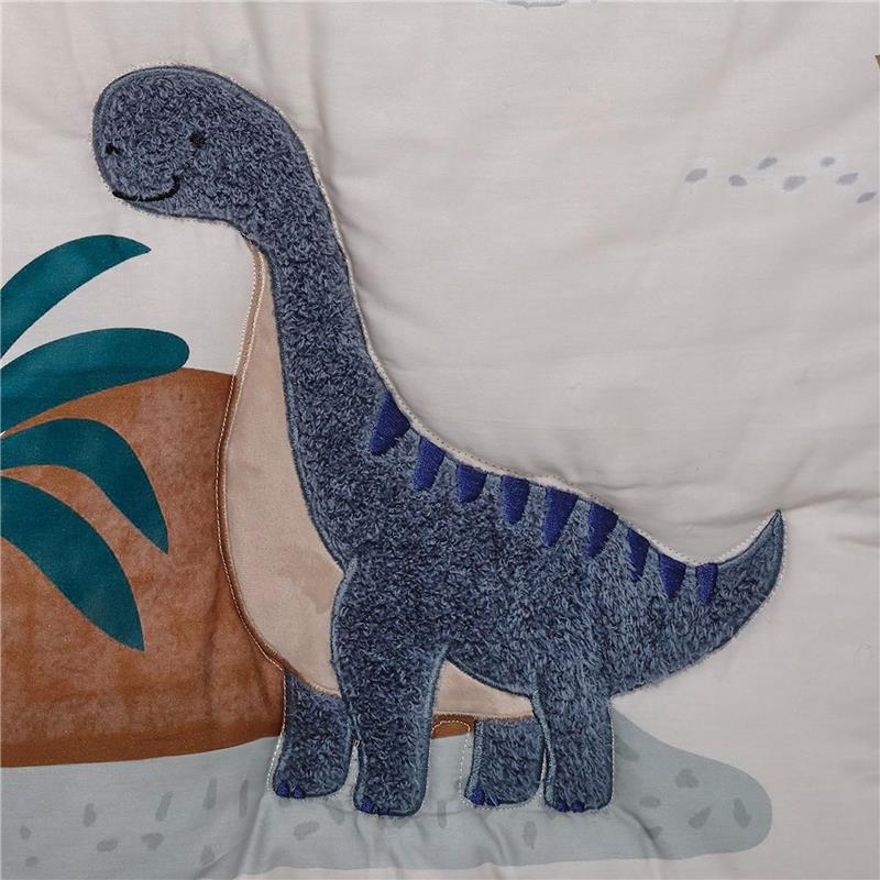 Soft blue and gray dinosaur applique with a friendly expression on a nursery bedding set.