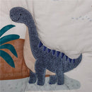 Soft blue and gray dinosaur applique with a friendly expression on a nursery bedding set.