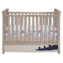 Blue and gray dinosaur-themed crib bedding set, featuring a fitted sheet and a decorative bed skirt with a dinosaur design.