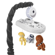 Baby musical mobile featuring the Millennium Falcon with plush Star Wars characters: C-3PO, R2-D2, and Chewbacca.