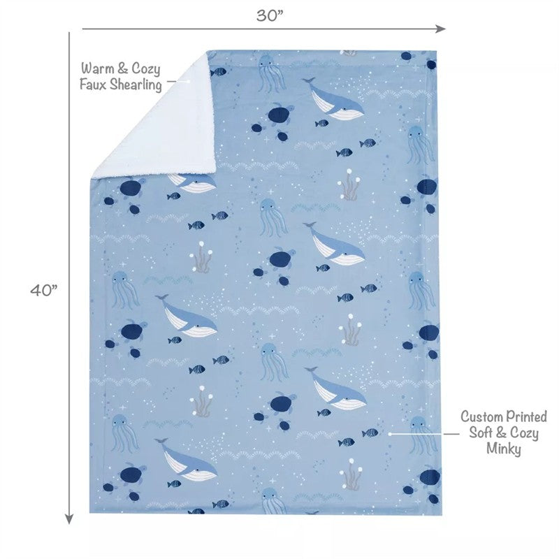 Baby blanket featuring a playful underwater design with whales, fish, and octopuses in soft blue tones.