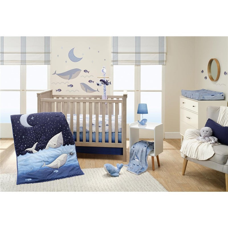 Lambs & Ivy Bubble & Squirt Changing Pad Cover featured in a nursery with whale-themed decor and a crib.