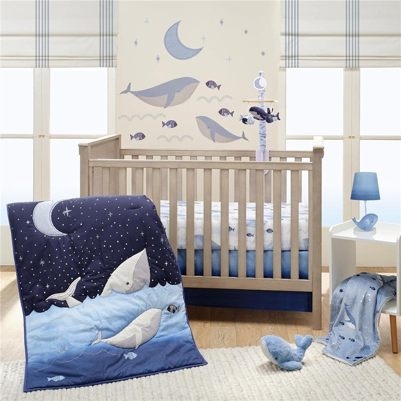 Plush whale nursery decor featuring a crib, whale-themed blanket, and wall art with stars and ocean elements.