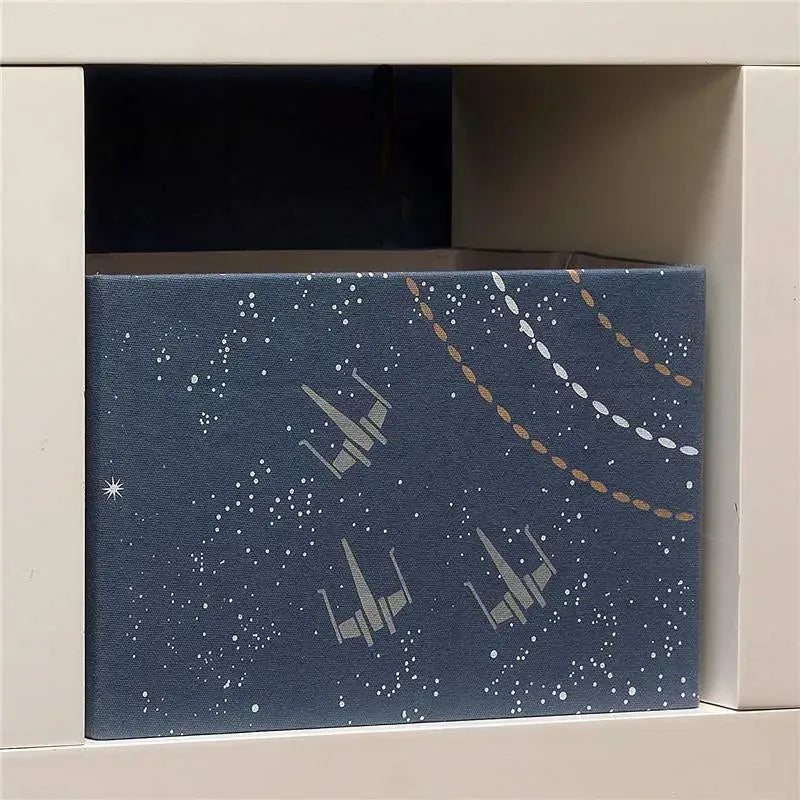 Collapsible storage bin organizer featuring a galaxy design with starry background and spaceship illustrations.