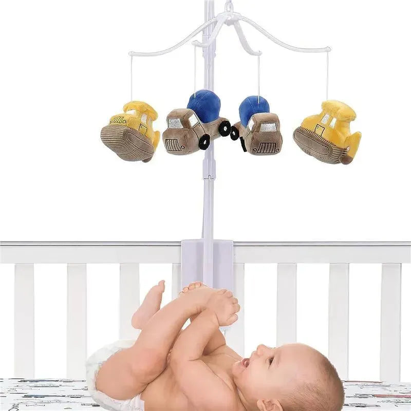 Construction Zone musical mobile featuring plush vehicles, with a baby lying in a crib reaching for it.