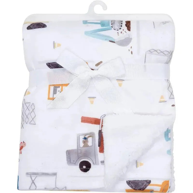 Cozy fleece baby blanket featuring construction-themed trucks and tools, with a soft white backing and decorative bow.