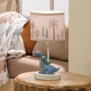 3D dinosaur nursery lamp featuring a blue dinosaur with a green baby dinosaur, topped with a palm tree print shade.