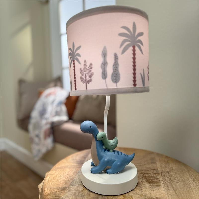3D dinosaur nursery lamp featuring a blue dinosaur with a green dinosaur figure, topped with a palm-patterned shade.