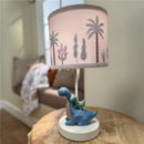 3D dinosaur nursery lamp featuring a blue dinosaur with a green dinosaur figure, topped with a palm-patterned shade.