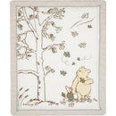 Lambs & Ivy Disney Storytime Pooh crib bedding set featuring Pooh and Piglet beneath a tree with falling leaves.