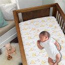 Baby sleeping in a crib with a Lambs & Ivy Disney Storytime Pooh bedding set featuring playful Pooh Bear patterns.